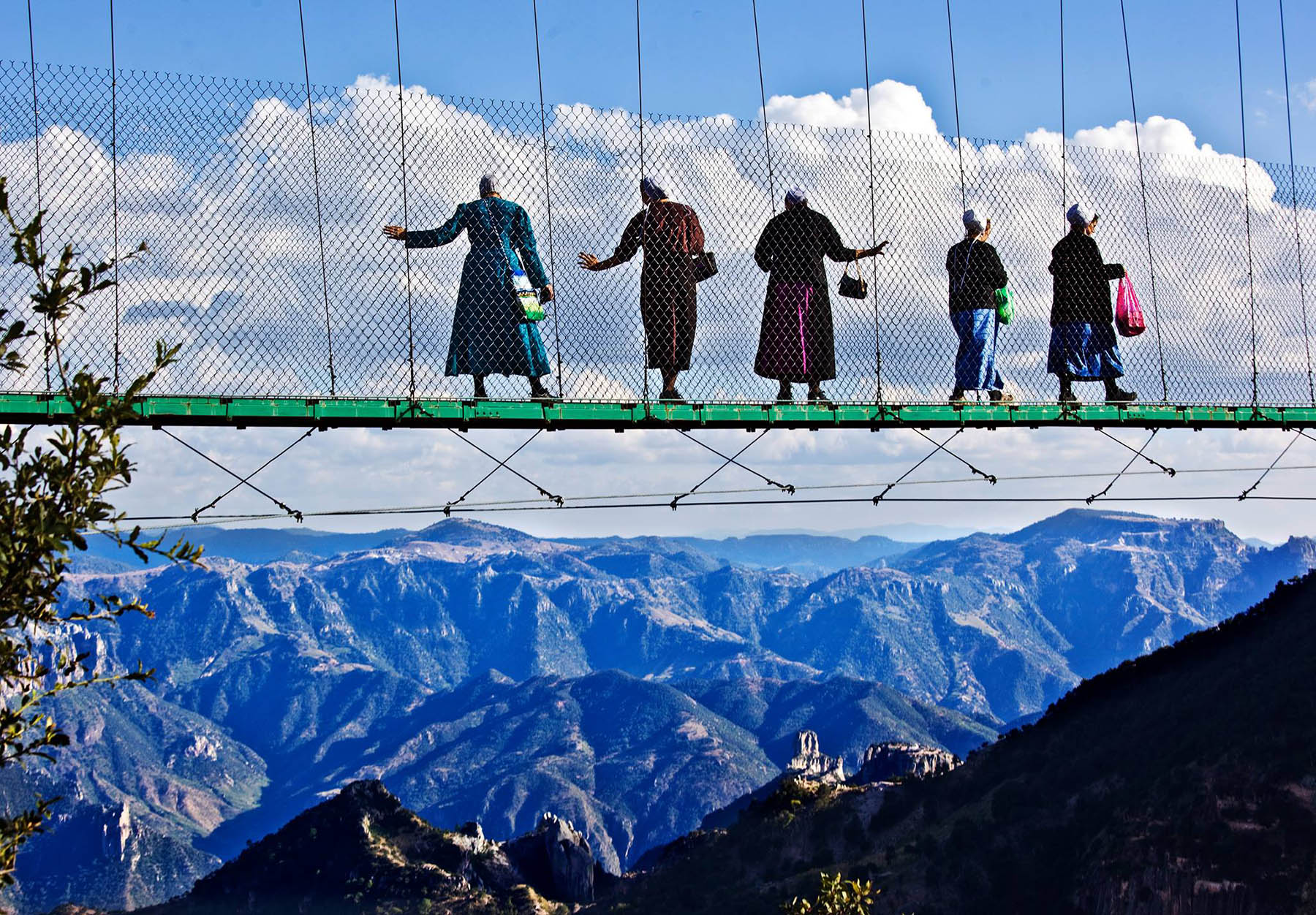 Fem mennonitter går over hengebroen ved Divisadero. Foto: Terje Bringedal
