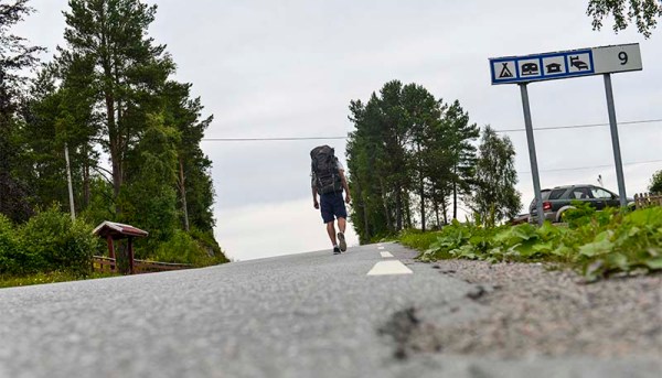 Backpacker går mot campingplass på budsjettreise i Norge